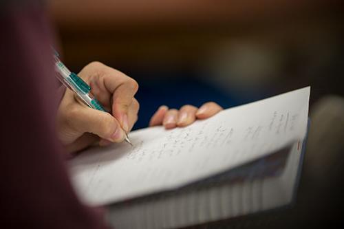 Person writing notes in a notebook.